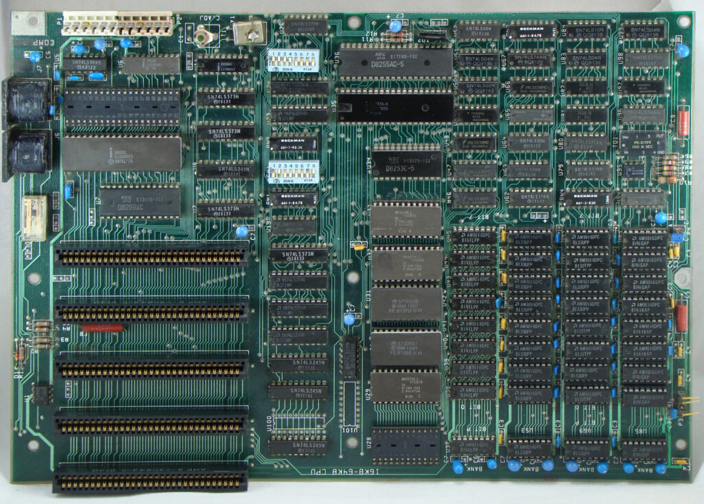IBM PC Motherboard from 1981. The IBM Personal Computer Model 5150 was the first computer of the type which is today (2023) generically known as a "PC". It had an Intel 8088 microprocessor with 4,77 MHz, five bus connector ports for expansion cards (ISA Bus, 8 Bit) and 16 KB to 64 KB RAM on the motherboard - installed on the pic are 32 integrated circuits (4x8 ICs below right) of the type AMD Am9016 with 16,384 Bits each (2 kByte), resulting in the RAM having the maximum installable size of 64 kByte. The additional 9th row separately below is most likely for parity checking (error control).